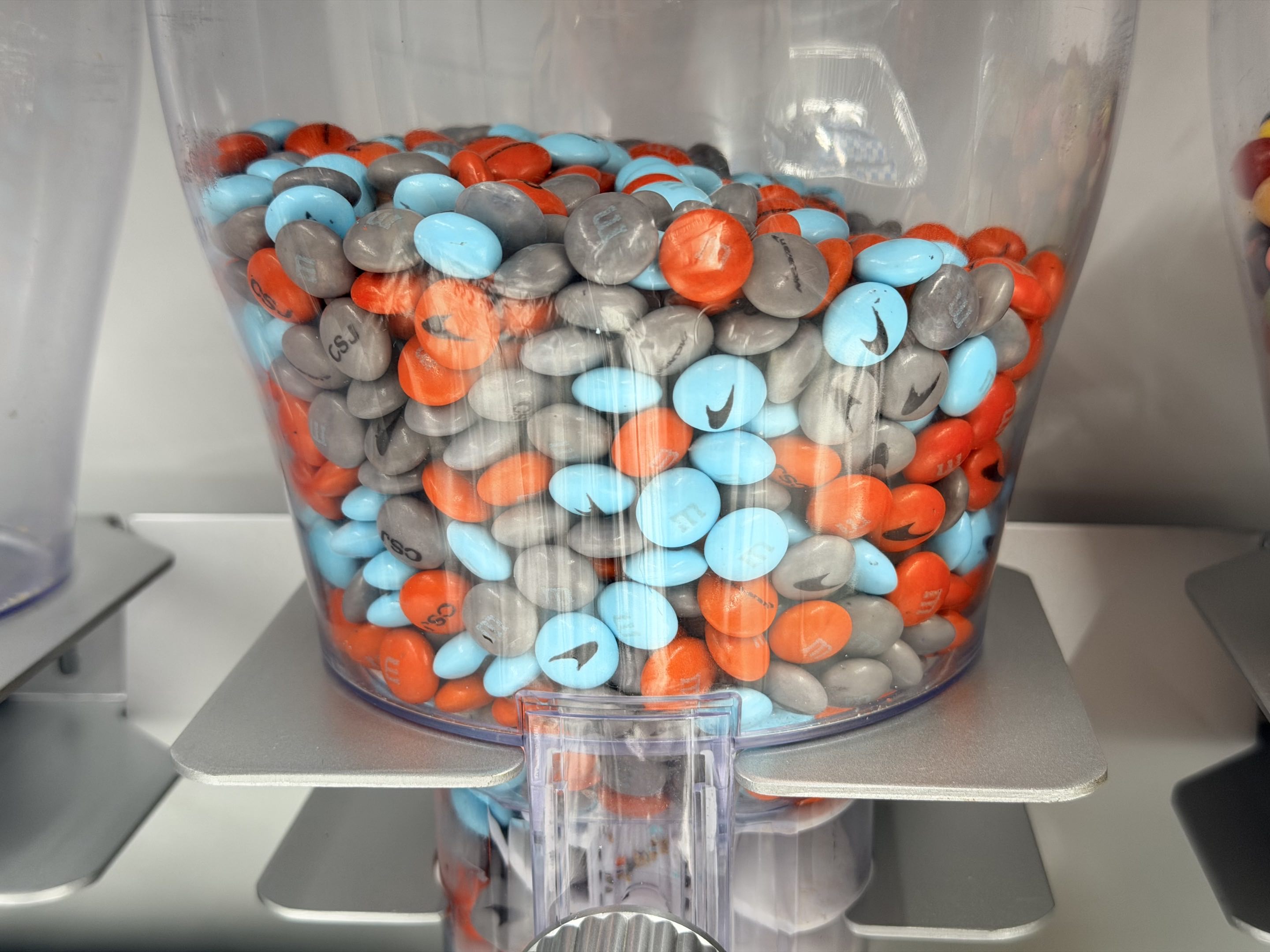 A glass jar of custom McLaren-colored and branded M&Ms